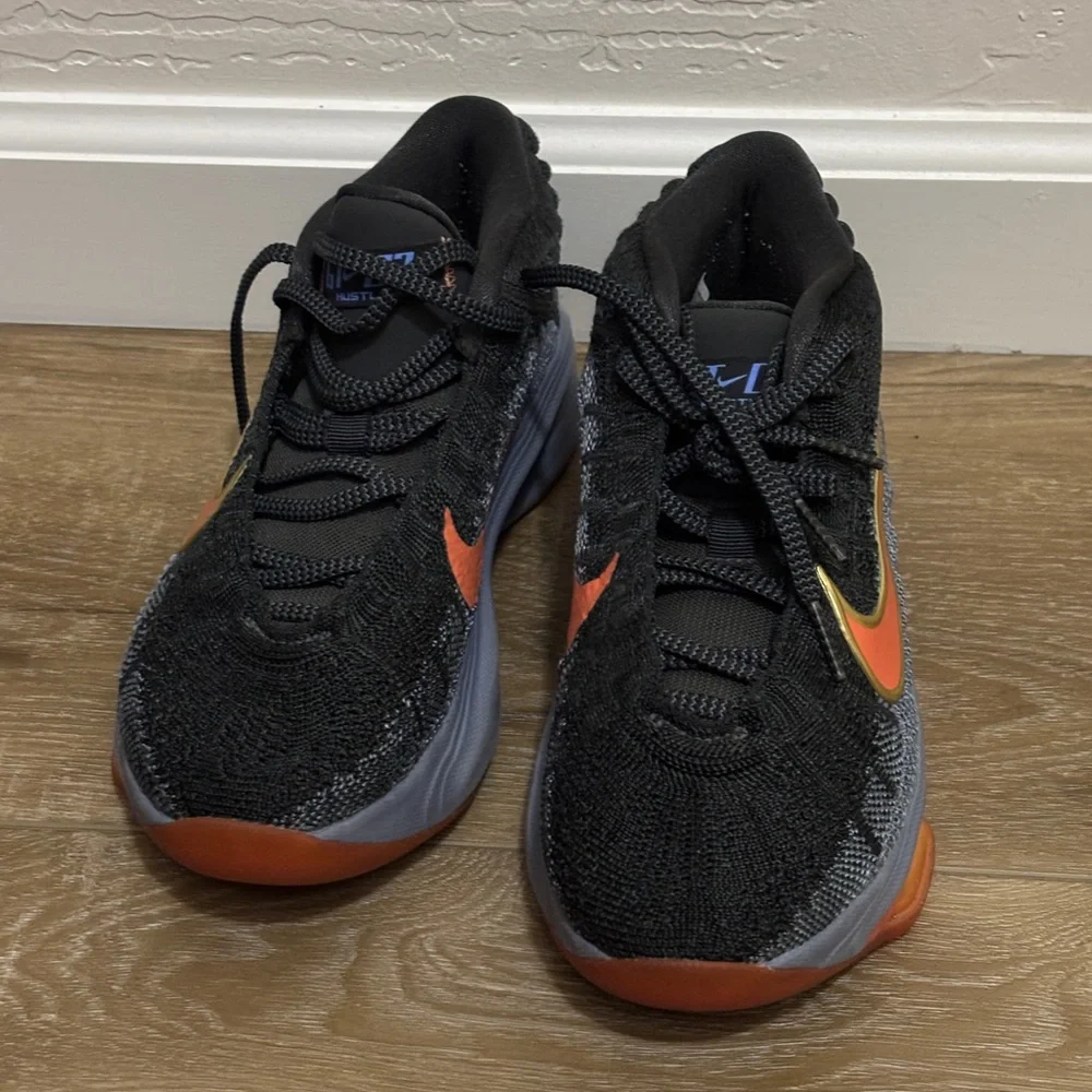 Nike Black Low-Top Sneakers with Orange & Gold Swoosh. Court shoes.